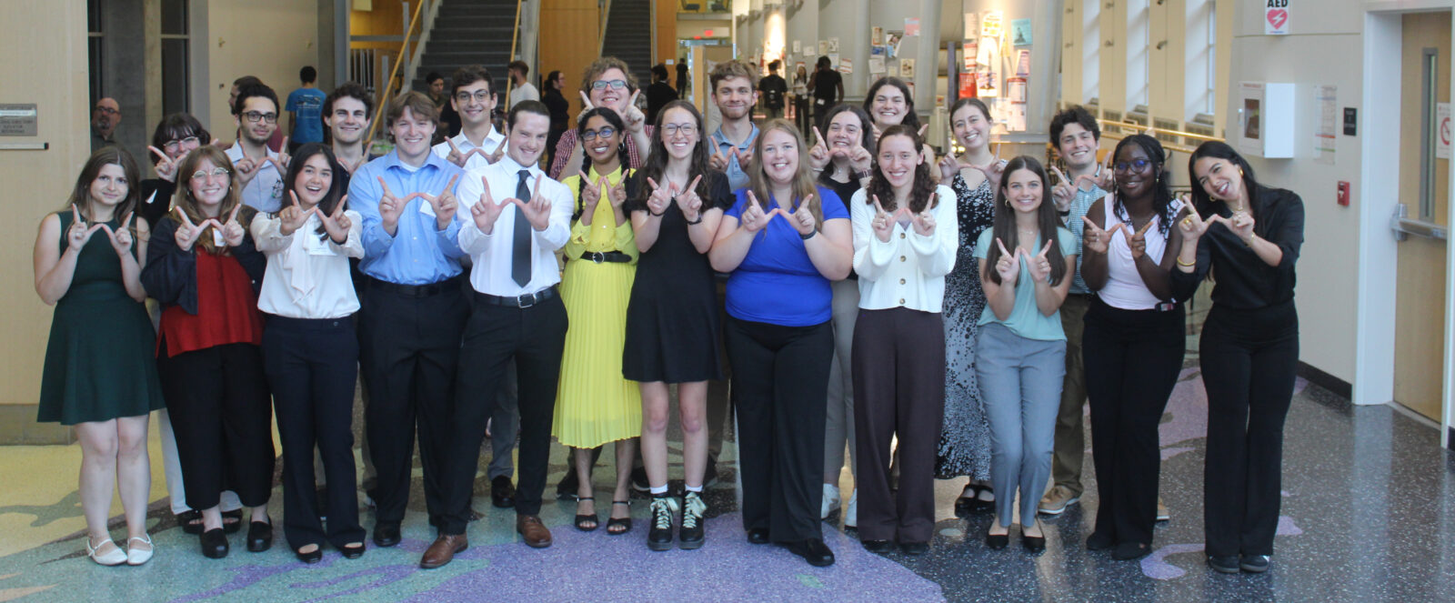 Group photo of an REU cohort with everyone making the "W" sign for the UW.
